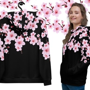 May include: Black hoodie with a pink cherry blossom print. The hoodie has a drawstring hood and a kangaroo pocket.