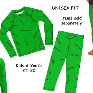 Puede incluir: Conjunto de ropa verde para niños y jóvenes con un patrón de costura de Frankenstein. El conjunto incluye una camisa de manga larga y leggings. El texto "UNISEX FIT" y "artículos vendidos por separado" son visibles. Tallas de 2T a 20.
