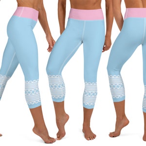 May include: Light blue capri leggings with a pink waistband and white lace-like trim at the ankles. The leggings are made of a stretchy material and are designed for athletic activities. The leggings are shown from multiple angles.