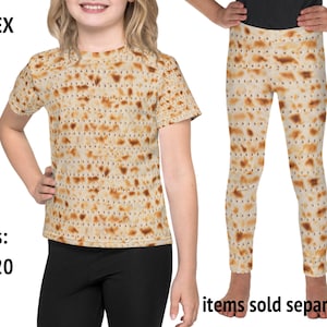 Pode incluir: Camiseta e leggings unissex com um padrão de matzá. A camiseta tem gola redonda e mangas curtas. As leggings são de comprimento total. Tamanhos 2T-20. Itens vendidos separadamente.