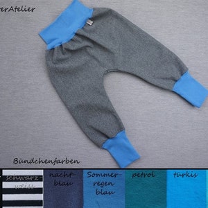 Könnte beinhalten: Graue Jogginghose mit blauem elastischem Bund und Bündchen. Die Jogginghose ist vor einem grauen Hintergrund abgebildet. Der Text "Bündchenfarben" ist unter der Jogginghose sichtbar. Unter dem Text ist eine Farbkarte mit folgenden Farben abgebildet: schwarz, schwarz-weiss, nachtblau, sommerregenblau, petrol, türkis, atlantis.