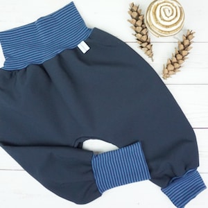 May include: Dark blue baby trousers with blue and white striped trim around the waist and legs.