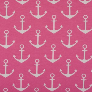 Könnte beinhalten: Nahaufnahme eines pinkfarbenen Stoffes mit einem sich wiederholenden Muster aus weißen Ankern. Die Anker sind gleichmäßig verteilt und erzeugen ein maritimes Thema. Der Stoff hat eine glatte Textur.