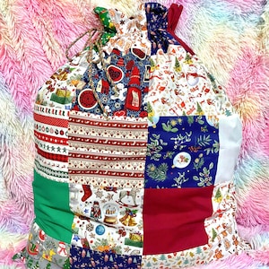 May include: A large patchwork Christmas gift bag with a drawstring closure. The bag is made of various fabrics with different Christmas-themed patterns, including red, green, blue, and white.