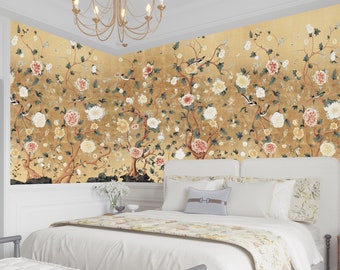 Könnte beinhalten: Ein Schlafzimmer mit einem weißen Bett und einer floralen Tapete mit goldenem Hintergrund, weißen und rosa Blumen und Vögeln.