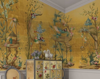 Op de afbeelding: Een gouden behang met een geschilderd tafereel van een fantasierijke tuin met bomen, bloemen en vogels. Het behang heeft een herhalend patroon van bomen met kleine huisjes en vogels die op takken zitten. Het behang is een mooie en unieke toevoeging aan elke kamer.