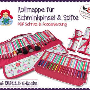 May include: A red and white striped fabric roll-up case with a floral pattern on the inside. The case is designed to hold makeup brushes and pencils. The case is rolled up and tied with a ribbon. The text "Rollmappe für Schminkpinsel & Stifte" is printed on the top of the case. The text "PDF Schnitt & Fotoanleitung" is printed below the first line of text. The text "You Tube Videoanleitungen zum eBook" is printed in a red box on the right side of the image. The text "Sami DOLLS E-Books" is printed at the bottom of the image.