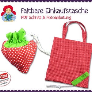 Op de afbeelding: Een rode boodschappentas van stof met witte stippen en een groene stoffen handvat. De tas is opgevouwen en heeft een wit trekkoord. De tas is gelabeld met "Faltbare Einkaufstasche" en "PDF Schnitt & Fotoanleitung".