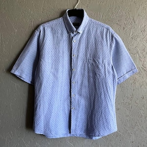 May include: A light blue short-sleeved button-down shirt with a white polka dot pattern.