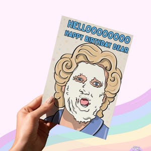 May include: A greeting card with the text "HELLOOOOOOOOO HAPPY BIRTHDAY DEAR" features a cartoon illustration of a person with a face mask. The card is held by a hand against a pastel rainbow background.