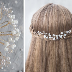 May include: Set of gold hair pins with white pearl and flower accents. The pins are arranged in a fan shape and are held in a hand. The pins are shown in a close-up view.