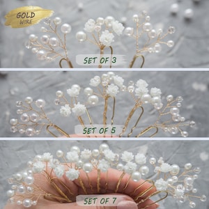 May include: Set of gold wire hair pins with white pearl beads and small white flowers. The sets are available in sizes of 3, 5, and 7.