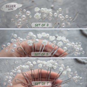 May include: Set of three, five, and seven silver wire hair pins with white pearl beads and small white flowers.  The text "SET OF 3", "SET OF 5", and "SET OF 7" is visible in the image.