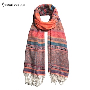 Könnte beinhalten: Ein pfirsichfarbener Schal mit einem mehrfarbigen Streifenmuster und weißen Fransen. Das Muster enthält Blautöne, Rosa und Grün.