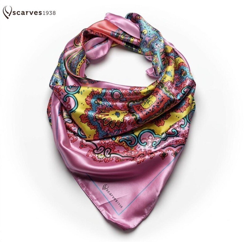 May include: A square satin scarf featuring a vibrant paisley pattern in shades of pink, yellow, and blue. The scarf has a smooth, reflective finish and includes the text "scarves1938" printed in the corner and at the top left of the image.