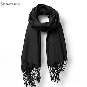 May include: A black scarf with fringe detailing. The scarf is draped and displayed against a white background. The brand name "scarves1938" is in the upper left corner.