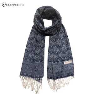 以下が含まれることがあります： 白いフリンジが付いた青い模様のストール。ストールは花柄で、タグに「Paspaley」の文字が見えます。