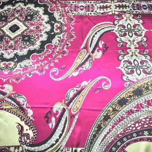 May include: A pink fabric with a paisley pattern in shades of brown, black, and white. The fabric has a satin finish.