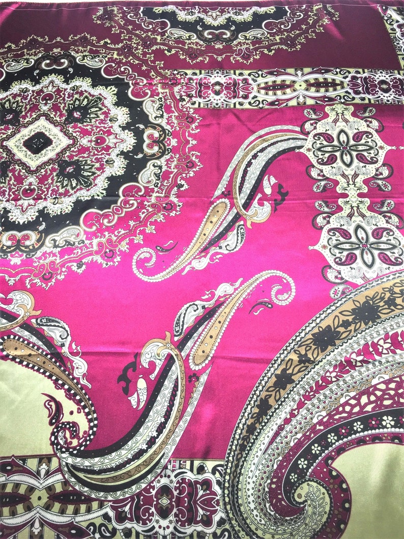 May include: A pink fabric with a paisley pattern in shades of brown, black, and white. The fabric has a satin finish.