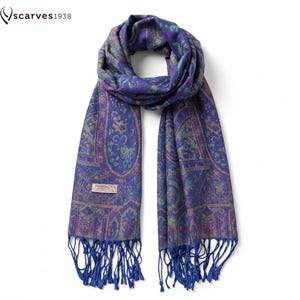 Może przedstawiać: Szal Pashmina w odcieniach niebieskiego, fioletowego i zielonego ze skomplikowanym wzorem paisley. Szal ma frędzle na końcach i metkę z napisem "Pashmina". Szal pochodzi z "scarves1938".