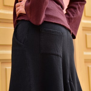 Pu&ograve; includere: Una gonna nera con una grande tasca sul retro. La gonna &egrave; realizzata in un tessuto morbido e confortevole e ha una vestibilit&agrave; fluida e rilassata.