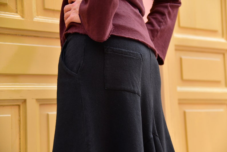 Pu&ograve; includere: Una gonna nera con una grande tasca sul retro. La gonna &egrave; realizzata in un tessuto morbido e confortevole e ha una vestibilit&agrave; fluida e rilassata.
