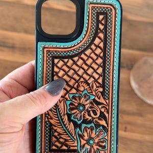 Turkos läderskal med westernmotiv och blommönster på iPhone 14