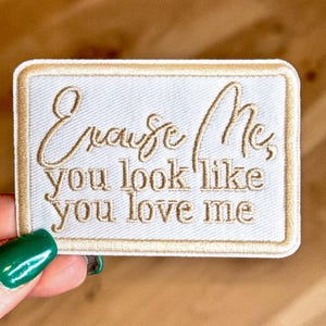 May include: White embroidered patch with a gold border. The text on the patch reads "Cause Me, you look like you love me."