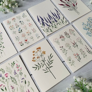 K&ouml;nnte beinhalten: Satz von acht leeren Gru&szlig;karten mit handgemalten Aquarell-Illustrationen verschiedener Blumen und Pflanzen. Die Karten sind wei&szlig; mit einer dezenten Textur und haben eine leere Innenseite zum Schreiben von Nachrichten.