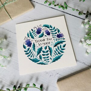 May include: A white card with a blue and green floral design and the text "Thank You So Much".