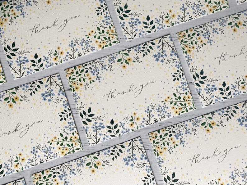 Puede incluir: Un conjunto de cinco tarjetas de agradecimiento con un dise&ntilde;o floral. Las tarjetas son blancas con un patr&oacute;n floral azul claro y amarillo y las palabras "Gracias" escritas en cursiva negra.