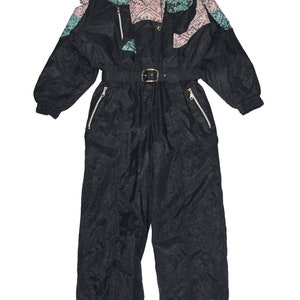 May include: Black ski suit with a pink, green, and black geometric pattern on the shoulders and chest. The suit has a belt and zippered pockets.