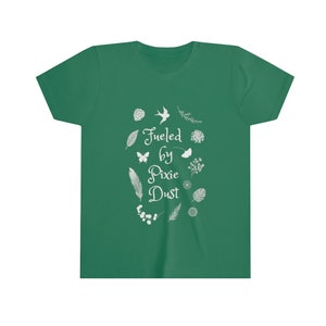 May include: A green youth t-shirt with a white graphic design featuring the text "Fueled by Pixie Dust" surrounded by small white floral and leaf illustrations.
