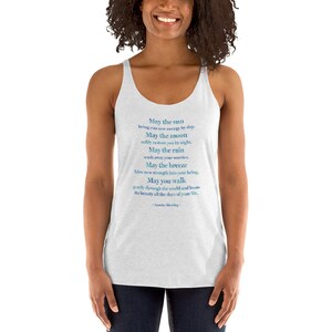 May include: A white tank top with a blue and green inspirational quote that reads "May the sun bring you new energy by day. May the moon softly restore you by night. May the rain wash away your worries. May the breeze blow new strength into your being. May you walk gently through the world and know its beauty all the days of your life. -Apache Blessing-"