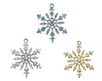 Puede incluir: Tres abalorios de copo de nieve con detalles de cristal. Los abalorios de copo de nieve son plateados, dorados y plateados con cristales azules.