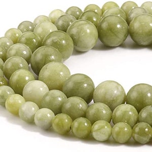 May include: A strand of light green jade beads, each bead is smooth and round. The beads are strung together on a clear thread.