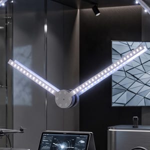 以下が含まれることがあります： 透明な文字盤とシルバーのフレームを備えた円形の壁掛け時計で、外周と針に沿ってLEDライトが組み込まれています。文字盤の中央には、白い文字でADVPROと記されています。