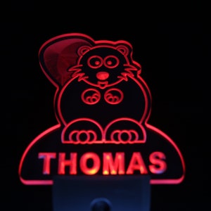 May include: Red LED night light shaped like a cartoon beaver with the name "THOMAS" underneath.
