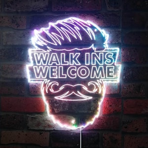 Może przedstawiać: Neonowy znak z  stylizowanym wizerunkiem twarzy mężczyzny z brodą i wąsami. Na znaku widnieje napis "Walk Ins Welcome".