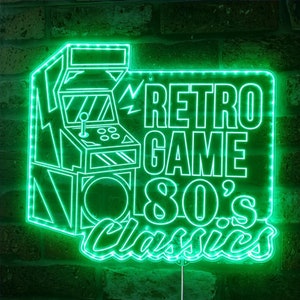 May include: A neon green sign with the words "RETRO GAME 80's Classics" and an arcade game machine outline. The sign is mounted on a brick wall and has a bright, glowing effect.
