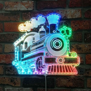 May include: A vibrant LED train light fixture. The train design features a neon-style outline, with colours shifting from blue to green and red. It's mounted on a brick wall.