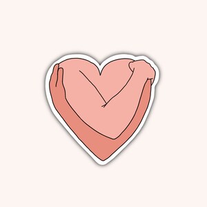 May include: A sticker featuring a heart shape formed by arms embracing themselves. The arms and heart are in shades of pink, outlined in black, and set against a light pink background. The design conveys self-love and care.