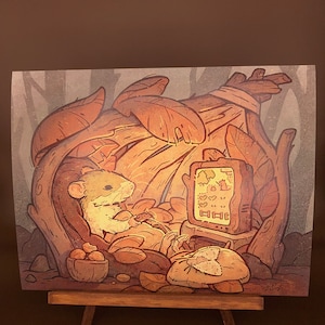 May include: A cartoon illustration of a small, brown mouse sitting in a cozy, leafy nest and watching a television screen with a video game on it. The mouse is holding a controller and has a relaxed expression. The nest is made of leaves and branches, and there are nuts and other forest elements scattered around.