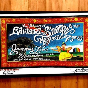May include: A vintage concert poster with a colorful illustration of a fairy holding a wand. The poster advertises a show by Edward Sharpe and the Magnetic Zeros at Jannus Live in St. Petersburg, Florida on September 12th. The poster is framed in black and has a red, white, and blue border.
