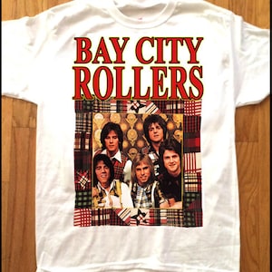 May include: White t-shirt with the words "BAY CITY ROLLERS" in red and gold. The shirt has a colourful image of the band, framed by a patchwork design.