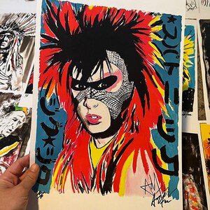 May include: A vibrant pop art print featuring a portrait of a person with bold red hair and a black mesh mask. The artwork includes Japanese text on a blue background and is signed by the artist. The style is reminiscent of punk rock aesthetics.