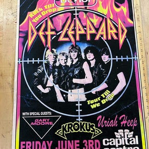 Könnte beinhalten: Ein Vintage-Konzertplakat von Def Leppard mit schwarzem Hintergrund und rosa und gelben Akzenten. Das Plakat zeigt die Bandmitglieder, das Logo der Band und den Text "Rock Till You Drop". Das Konzertdatum ist der 3. Juni.