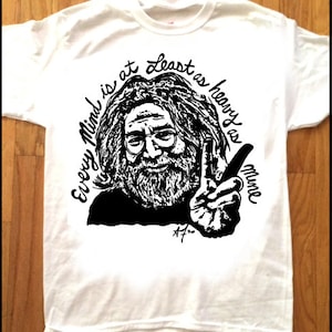 以下が含まれることがあります： 白地に黒と白のイラストがプリントされたTシャツ。イラストは、長髪でひげを生やした男性。イラストの周りに「Every Mind is at least as heavy as mine」という文字がプリントされている。