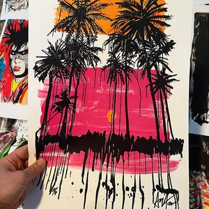 May include: A vibrant art print featuring black palm trees against a sunset backdrop of orange and pink hues. The artwork has a bold, graphic style with dripping paint effects, creating a striking tropical scene.