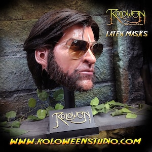 May include: A realistic latex mask of a man with a beard and sunglasses. The mask is on a black stand with the words "Roloween Studio" in gold lettering. The text "Latex Masks" is also visible in the image.